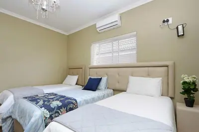 a bedroom with two beds and a window at Camdene Guesthouse in Cape Town