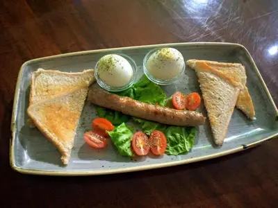 a plate of food with a sausage and toast at Camdene Guesthouse in Cape Town