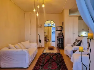 a living room with two white couches and a table at 'Top Flat' Apartment with Easy Beach Access, Sea front sleeps 5 in Gordonʼs Bay