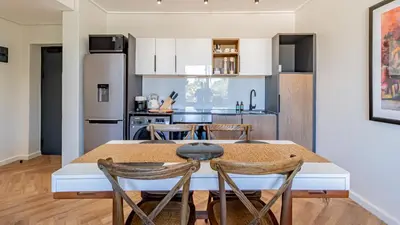 a kitchen with a table and chairs and a refrigerator at Table Mountain View Apartment in Cape Town