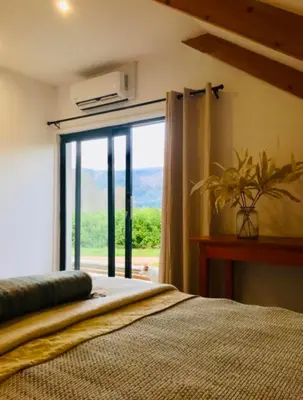 a bedroom with a bed and a large window at Beertjie Bos in Paarl