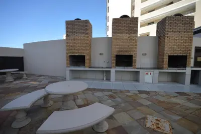 a patio with a table and benches in a building at 402 Ocean View in Strand