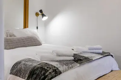 a white bed with towels on top of it at Bed On Boucher in Durbanville
