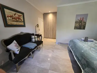 a living room with a couch and a bed at Susans Cottage Peace and Quiet in Villiersdorp