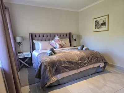 a bedroom with a large bed with a brown comforter at Susans Cottage Peace and Quiet in Villiersdorp