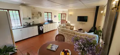 a living room with a couch and a table at Sunkiss Cottage on Mount Joy Farm in Stellenbosch