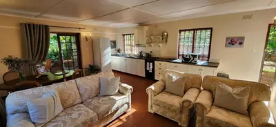 a living room with two couches and a kitchen at Sunkiss Cottage on Mount Joy Farm in Stellenbosch