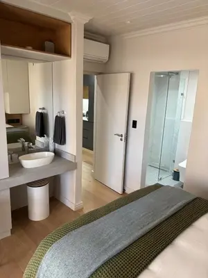 a bathroom with a bed and a sink and a shower at Modern living in central town in Stellenbosch