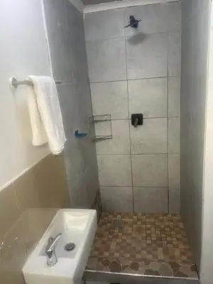 a bathroom with a shower with a toilet and a sink at Optimum Stay Self Catering Accommodation - Junior Suite in Parow