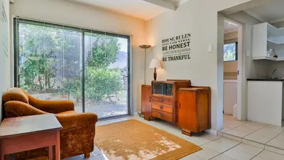 a living room with a couch and a tv and a window at BluCabana 500m from Main Beach in Bettyʼs Bay