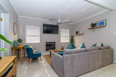 a living room with a couch and a fireplace at Pikkewyn Paradise in Hermanus