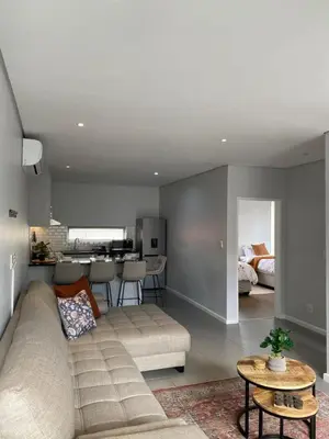 a living room with a couch and a kitchen at Boerbok & Bloom in Paarl