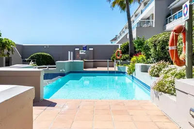 a swimming pool in the middle of a building at Dolphin Beach H305 in Cape Town