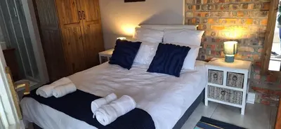 a bedroom with a bed with white sheets and pillows at Firehouse guest suite no 3 in Wellington