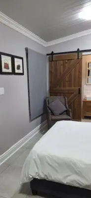 a bedroom with a bed and a chair at Firehouse guest suite no 3 in Wellington