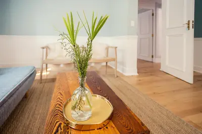 a vase with plants in it on a coffee table at Roubaix House - A Heritage Retreat in the Heart of Franschhoek in Franschhoek