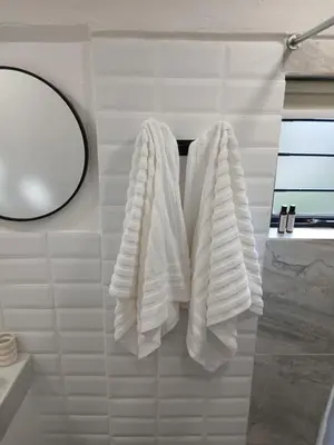 two white towels hanging on a rack in a bathroom at Petite Vine in Stellenbosch