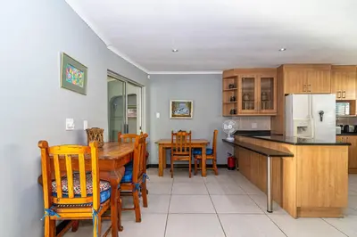 a kitchen and dining room with a table and chairs at Four Pines in Hermanus