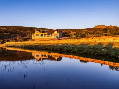 a house sitting on the side of a river at Blue Crane House