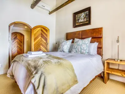 a bedroom with a large bed with a wooden headboard at Blue Crane House