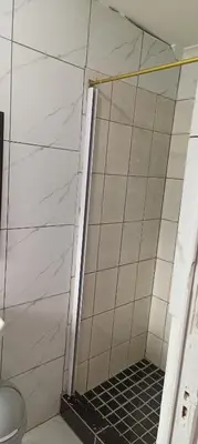 a shower with a black grate in a bathroom at PEACEFUL SLEEP lodge in Goodwood