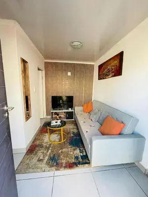 a living room with a couch and a tv at Kay's Guest Apartments in Kraaifontein
