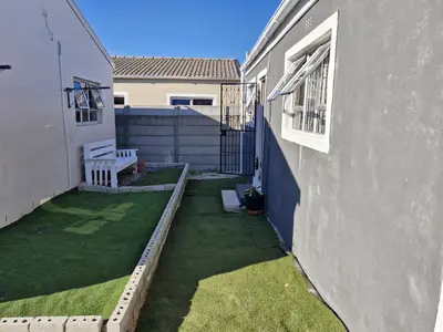 a small yard with a bench next to a building at Kay's Guest Apartments in Kraaifontein
