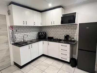 a kitchen with white cabinets and a black refrigerator at Casa Bracken in Windsor Park