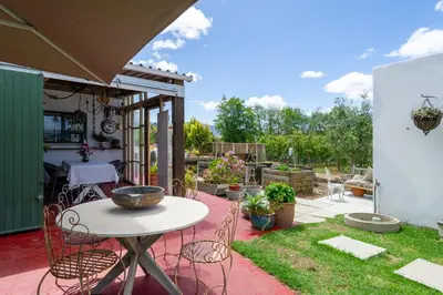a patio with a table and chairs in a yard at The smallest farm in Africa ELGIN in Grabouw