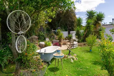 a garden with a bath tub in the grass at The smallest farm in Africa ELGIN in Grabouw