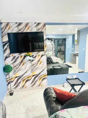 a living room with a wall with a large tv at Browns villa and construction pty ltd in Cape Town