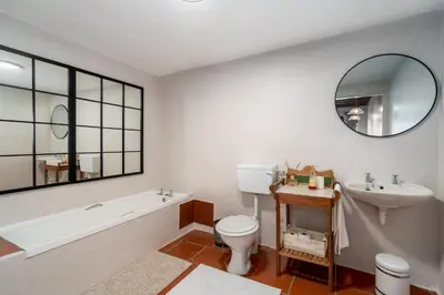 a bathroom with a tub and a toilet and a sink at Grietjiesdrif- Mountain Retreat in Rawsonville