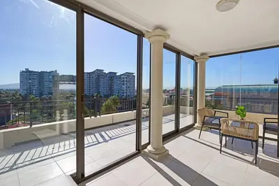 an empty balcony with a view of a city at 8 Sleeper Luxury Duplex Penthouse in Cape Town