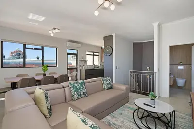 a living room with a couch and a dining room at 8 Sleeper Luxury Duplex Penthouse in Cape Town