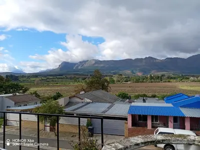 a house with a blue roof with mountains in the background at Paradise view in Paarl
