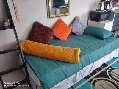 a bed with colorful pillows on it in a room at Paradise view in Paarl