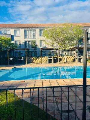 a swimming pool in front of a building at 2 bedroom flat in Pinelands near Old Mutual in Cape Town