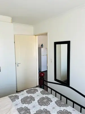 a bedroom with a bed and a mirror at 2 bedroom flat in Pinelands near Old Mutual in Cape Town