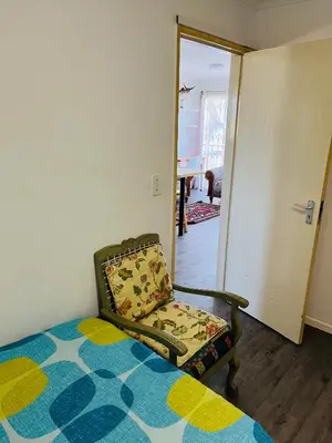 a bedroom with a bed and a chair in it at 2 bedroom flat in Pinelands near Old Mutual in Cape Town