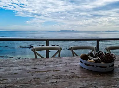 a bowl of food sitting on a table near the ocean at PENTHOUSE Luxury Apartment Amazing Sea Views CAPE TOWN in Strand