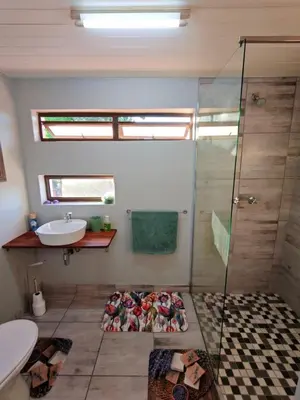 a bathroom with a shower and a sink at Sunbird Studio Apartment in Brackenfell