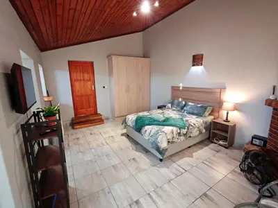 a bedroom with a bed and a wooden ceiling at Sunbird Studio Apartment in Brackenfell