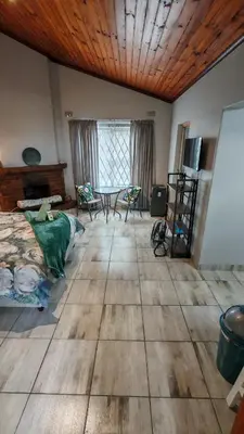a room with a bed and a table in it at Sunbird Studio Apartment in Brackenfell