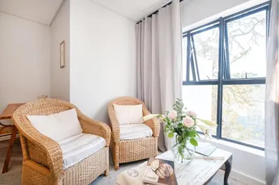 a living room with two chairs and a table at Olyfberg Rus in Paarl