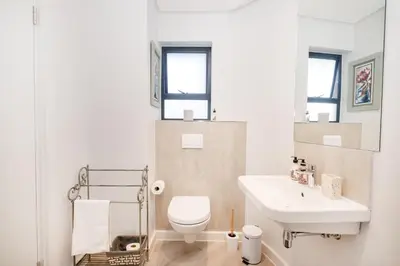 a bathroom with a white toilet and a sink at Olyfberg Rus in Paarl