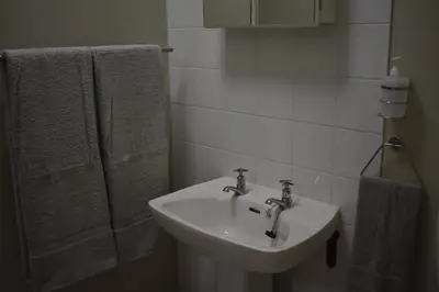 a bathroom with a sink and a shower with towels at Pualani Self Catering in Strand