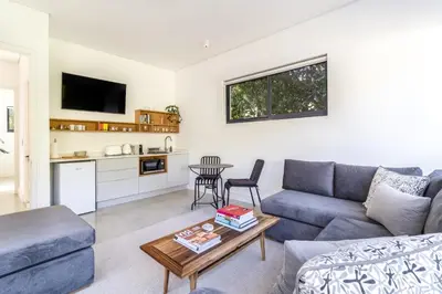a living room with a couch and a table at Contemporary Apartment With Shared Swimming Pool in Stellenbosch