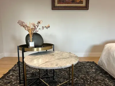 a table with a vase and a table with a stool at Guest Suite in Stellenbosch in Stellenbosch