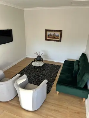 a living room with a green couch and a table at Guest Suite in Stellenbosch in Stellenbosch