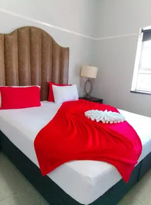 a bedroom with a large bed with a red blanket at Neo & Ruks Goodwood 1 in Goodwood